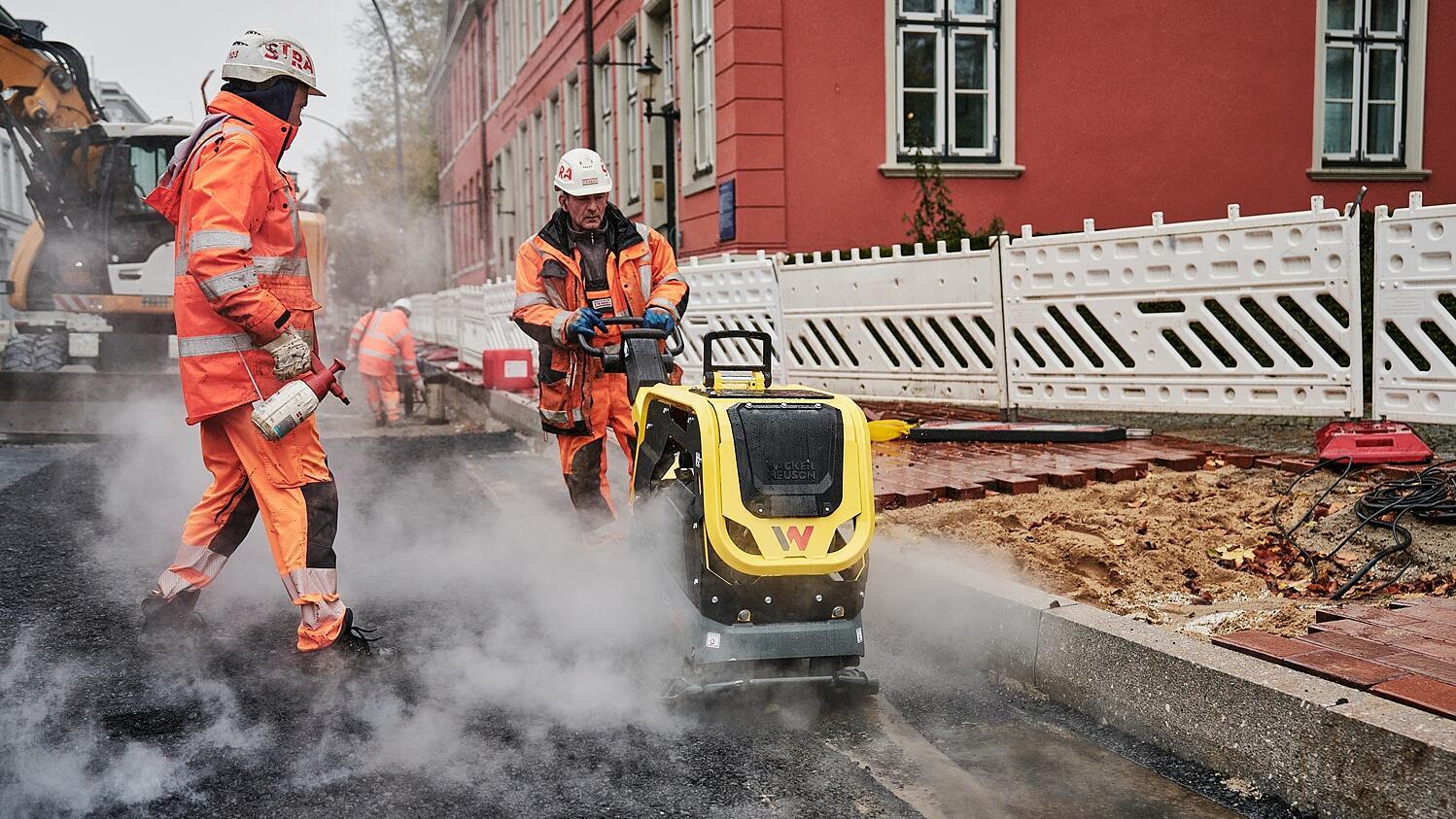Ouvriers du bâtiment pavant une route avec une DPU62