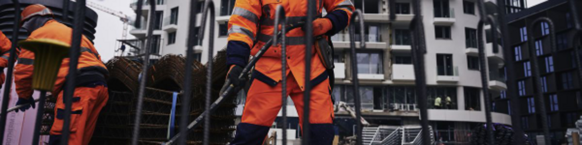 Bauarbeiter auf einer Baustelle, der mit einem Wacker Neuson Innenrüttler Beton verdichtet.