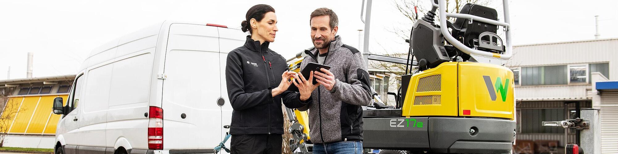 Een medewerker van Wacker Neuson en klant voor Zero Emission-rupsgraafmachine sluiten huurovereenkomst af.