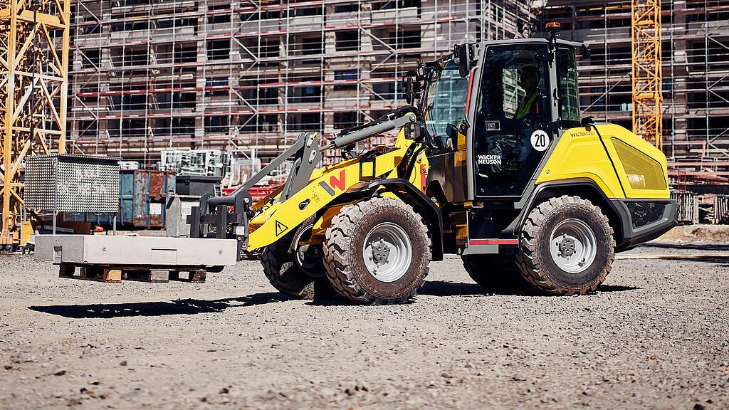 Wacker Neuson WL750p wheel loader unloading soil material and handling bulk material on a construction site.